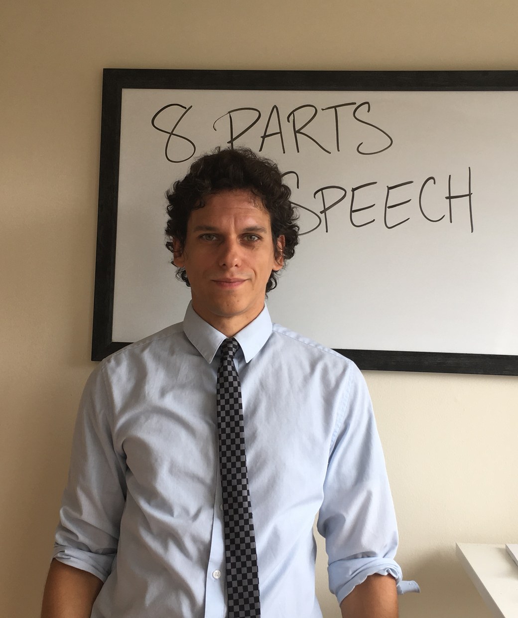 Andrés Cruciani in front of a whiteboard reading 8 Parts of Speech